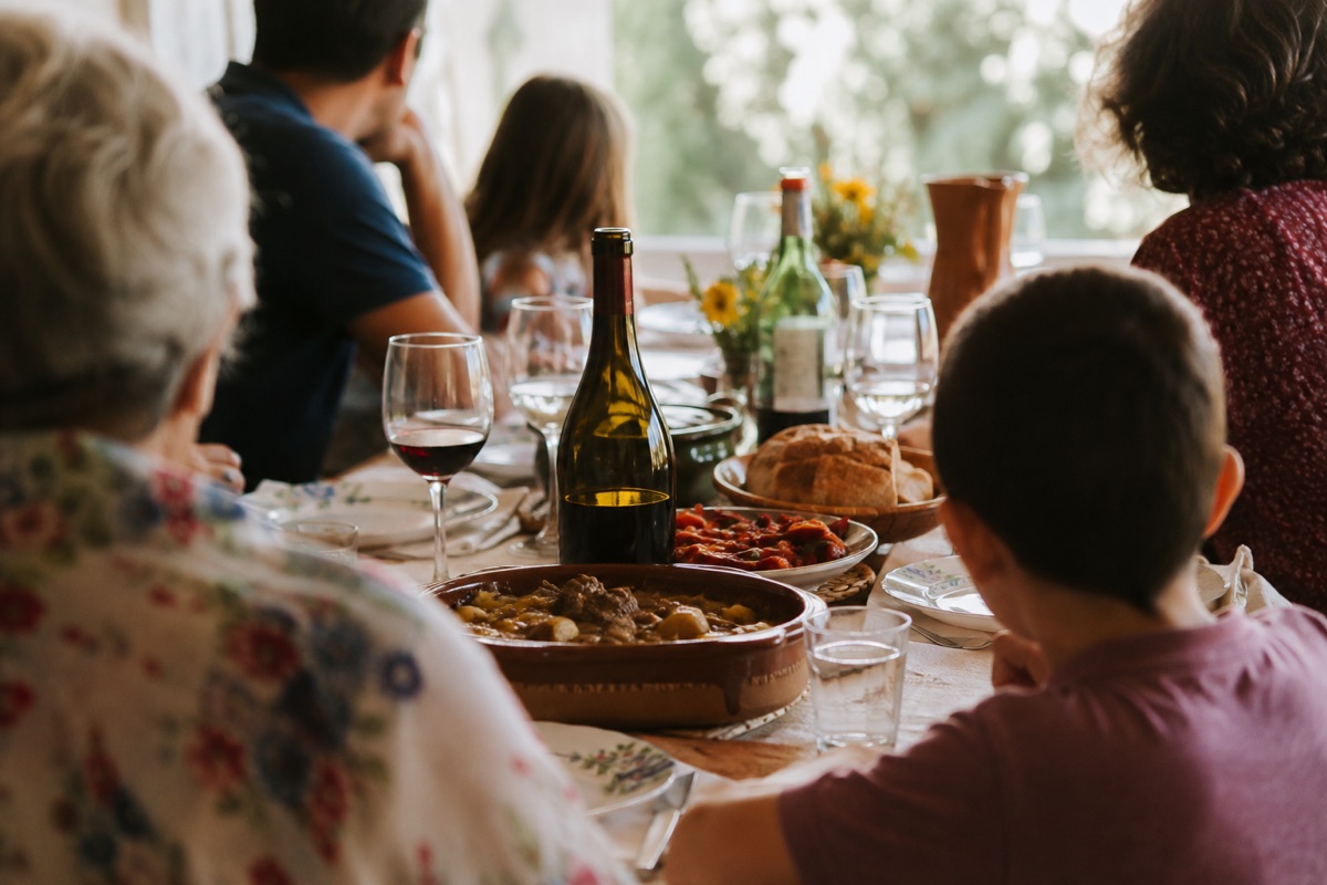 Familia compartiendo vino en una comida casera